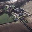 Oblique aerial view centred on the farmhouse and farmsteading, taken from the N.