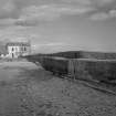 View of harbour wall, Cellardyke, from south west, with 1-2 Harbour Head in the distance.