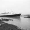 View looking SE showing QE II on River Clyde approaching Bowling with remains of pier in foreground