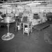 Tube Shop: view of one of three power presses (Machine No3), extruding detonator tube from coils of solid wire, in this case copper. Two other presses were producing aluminium tubes. A fourth machine produces detonator elements from Zinc wire (in background)