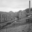 View of School, New Lanark, from South East with mill lade, side elevation of Institute and Retort House chimney.
