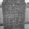 General view of West face of gravestone commemorating John Campbell, 1762, in the churchyard of Little Dunkeld Parish Church, showing weaving loom, angels, Adam and Eve, crossed bones, skull and hourglass.