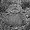 View of headstone commemorating Alexander Grinton and Janet Ingrum in the churchyard of Carriden Old Church, Bo'ness, with soul with large wings and Green Man below.