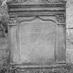 View of East face of gravestone commemorating Patrick Proudfoot and Janet Hunter d.1742, in the churchyard of Glencorse Old Parish Church, showing winged cherub in pediment and corinthian pilasters flanking inscription panel.