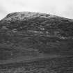 General view of hillside on which huts and wall occur.