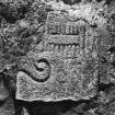 General view of Pictish stone bearing a double-sided comb symbol and possibly the round butt of a mirror handle.