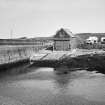 View from WSW of boat house and slipway, with harbour wall (left)