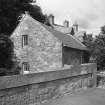 View of mill from SW, with bridge parapet in foreground.