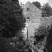 View from WSW of SW gable of mill, showing position of water-wheel pit, and dismantled water turbine.