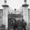 View of wrought iron north gates from the Newton Don walled garden, with two men, Nenthorn.