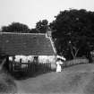 View of woman and child in front of unidentified house.