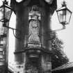 Detail of middle shaft from E showing statue of Mrs Gifford, gas lanterns and clockfaces.