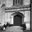 View of entrance including doorway, stained glass window above and steps.