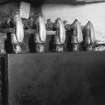 Interior. 
Detail of gas pipes and taps at the side of one of the two gas-fired griddles in the kitchen area.