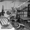 Interior. 
View of Scotch-pie-crust moulding machine in the pie-crust gallery with a tray of completed crusts.