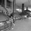 Alloa, Whins Road, Brewery, Brewhouse, first floor, interior
View showing brewhouse from W with its four traditional copper vessels. Mash tuns 1 and 2 are nearest the camera, the boiling copper (capacity of 220 barrels, which is a 'brew') and the lauter tun (19 feet 8 inches in diameter, 19 tons when empty, 45 tone when full) are visible. Hot liquor is run into mash tun no. 1 and some of this is pumped up into the copper tube carrying the malt mix from grist case no. 1. The liquor and partially mixed malt and liquor is mixed (with paddles) and heated to a pre-determined temperature for a pre-determined time before the resultant wort is pumped into the lauter tun and thence to the copper. Mash tun no. 2 (until 1980s a Decoction vessel or secondary mash vessel) was latterly used to heat liquor for the sparging process. The last mash took place on 19th/20th April 1999 but the brewhouse was re-commissioned for a mash which took place on 14th December 1999 when the Caledonian Brewery was damaged in a fire. The brewhouse coppers were installed in 1955 and were made by Christian Berner of Gothenburg, Sweden