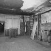 Interior. View from NE showing remains of wooden panelling and fireplace on 1st floor of warehouse ('Room 10')