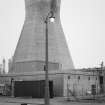 View of factory street lamp and concrete cooling tower.