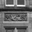 Detail of sculpted stone panel over ground floor window.