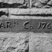 Fragment of inscribed cast-iron furnace lintel preserved in E wall of office block.