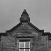 Detail of date plaque and finial over secondary entrance on S facade of main block.