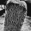 View of eighteenth century inscription on front face of reused medieval gravestone set on end.