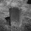View of chamfered edge on rear face of reused medieval gravestone set on end.