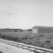 General view from SE of two surviving Quinan stove or drying houses, R18 and R19, latterly gutted and converted for use as narrow-gauge transit sheds.  Quinan stoves were used to dry nitrocotton, and there were originally 36 stoves, arranged in a rectangular 4 by 9 regular grid, all connected by tramway.