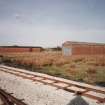 General view from SE of two surviving Quinan stoves or drying houses, R18 and R19, latterly gutted and converted for use as narrow-gauge transit sheds.  Quinan Stoves were used to dry nitrocotton, and there were originally 36 stoves, arranged in a rectangular 4 by 9 regular grid, all connected by tramway.