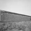 View from SE of surviving Quinan stove or drying house, building R18, latterly converted to a narrow-gauge transit shed.  The elevation in this view faces the central heater or apparatus house, and blocked pipe openings can be seen in the brickwork.