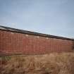 View from SE of surviving Quinan stove or drying house, building R18, latterly converted to a narrow-gauge transit shed.  The elevation in this view faces the central heater or apparatus house, and blocked pipe openings can be seen in the brickwork.