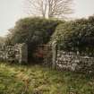 View of medieval graveslab in reuse as gatepost on S side of entrance, NY 2577 8019.