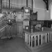 Detail of Communion table and pulpit with organ behind.