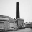 View from NW of boilerhouse chimney and enginehouse, beam engine house with cast iron roof tank by G. Graham of Carlisle.