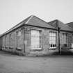 View from SW of part of SW side of the mill.  Single storeyed rubble built block with bays covered with hipped slate roofs.