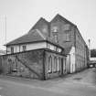 General view from N of the NE end of the works, showing the N gable of the High Mill, and the offices and gatehouse in the foreground.