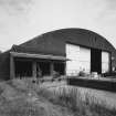 Oblique view from WSW of SSW end of hangar, showing added loading bay doors (left) and main (sliding) doors