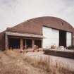 Oblique view from WSW of SSW end of hangar, showing added loading bay doors (left) and main (sliding) doors