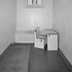 Detail of basement punishment cell with cardboard furniture