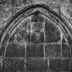 Detail of lower moulded arch with sculpted panel and inscription.