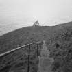 View from NE, looking down steep path and steps from lighthouse to fog horn.