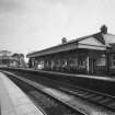 View from NW of S-bound platform, station offices and awning, with footbridge beyond