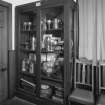 Vestry, cupboard containing chalices, pewter and silver ware and books, detail