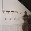 Wall adjacent to bottom of main stair, officers' coat hooks, detail