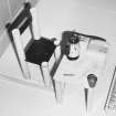 Upper level, main operations room, roof, jokey up side down miniature chair and table with telephone, papers, plastic cup and coffee pot on top, detail