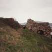 View of kiln from SSE, showing one of three draw arches, and brick vaulted passage beneath ramp (left)
