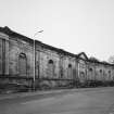 View from SSE of surviving facade of N part of works, also with M Nairn plaque