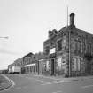 View from E of SE frontage onto Lawson Street, including name plaque at E corner of works