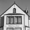 SW front, crow stepped gable with ball finial with two bipartite projecting windows below, detail