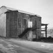 Cults Lime Works, view from SE of limestone hopper building used to supply crushed limestone to the kilns.  Built of brick and concrete with a recently installed corrugated iron roof, it was once connected by a bridge to the limestone quarry tramway system.